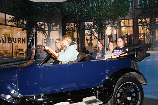 Students on a study trip to the Auburn Cord Duesenberg Automobile Museum in the photo car that was professionally restored by the “Pit Crew.”  Photo Credit: Auburn Cord Duesenberg Automobile Museum. 